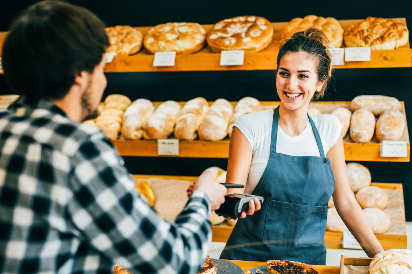 Kunde in Bäckerei bezahlt am Kartenterminal