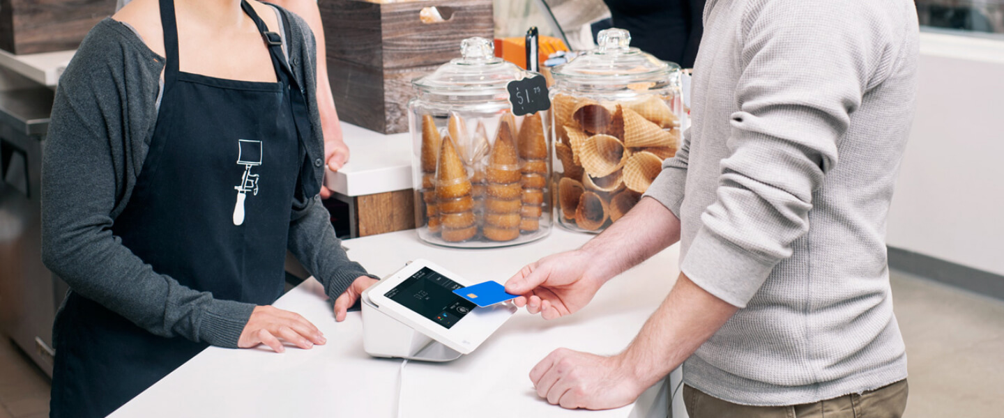Kunden in einer Eisdiele, die einen Clover-Automaten verwenden, um mit der Kartenzapffunktion zu bezahlen